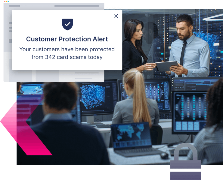 People in an office with computer monitors view a pop-up alert stating customers were protected from 342 credit card scams today.